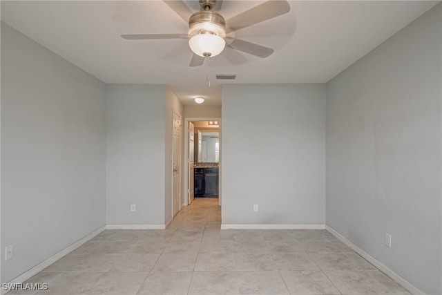 spare room featuring light tile patterned floors, visible vents, baseboards, and ceiling fan