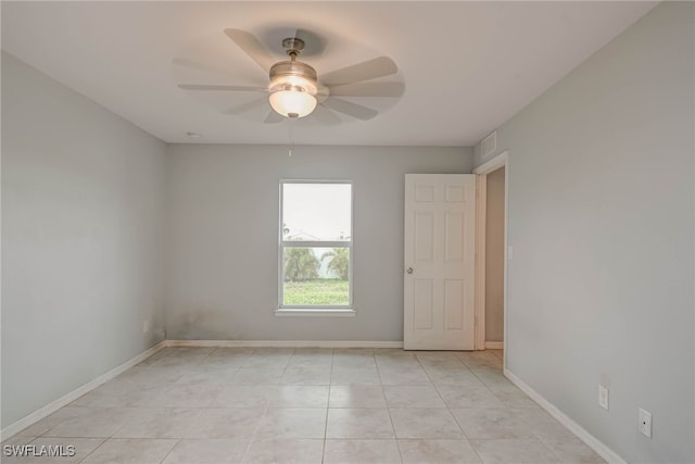 unfurnished room with visible vents, light tile patterned floors, a ceiling fan, and baseboards