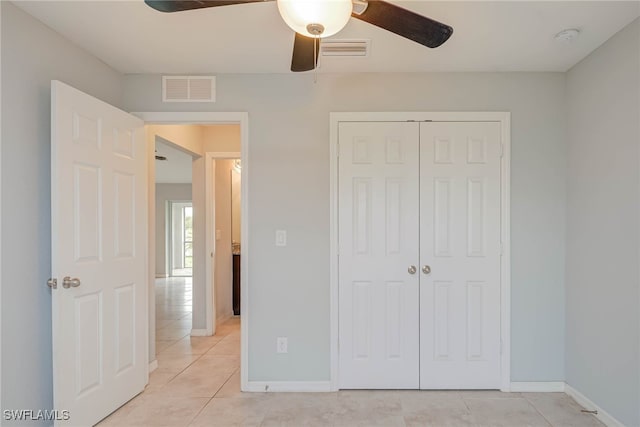 unfurnished bedroom featuring light tile patterned floors, visible vents, baseboards, and a closet