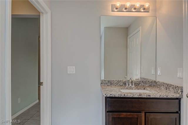 bathroom featuring tile patterned flooring, vanity, and baseboards