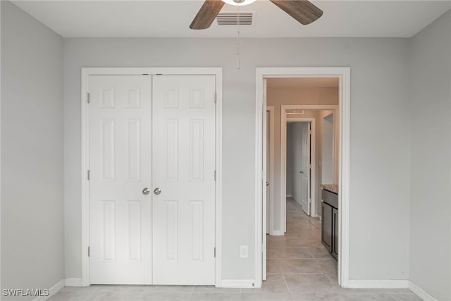 unfurnished bedroom featuring light tile patterned floors, visible vents, baseboards, and a closet