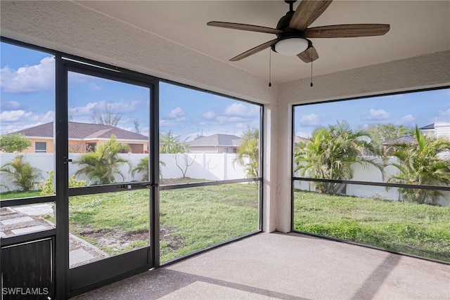 unfurnished sunroom featuring a ceiling fan