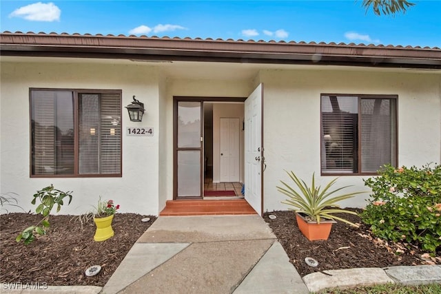 doorway to property featuring stucco siding