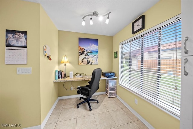 office area featuring rail lighting, light tile patterned flooring, and baseboards