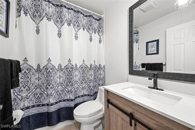 bathroom with vanity, toilet, and visible vents