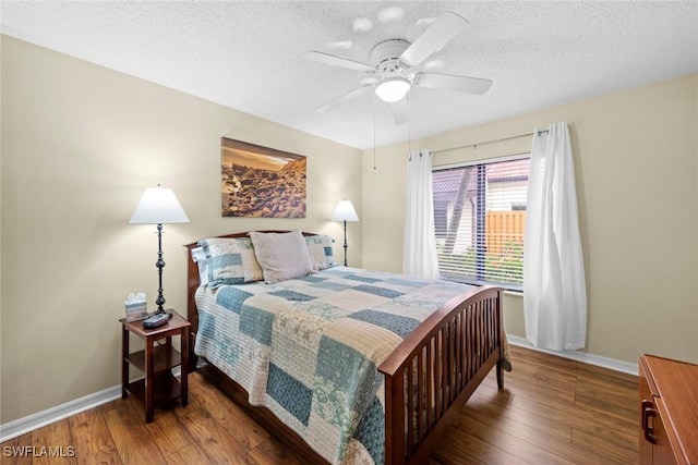 bedroom featuring a textured ceiling, baseboards, and hardwood / wood-style floors