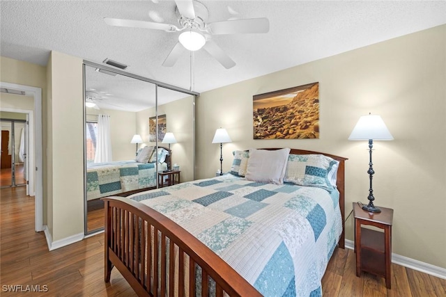 bedroom featuring visible vents, a textured ceiling, and wood finished floors