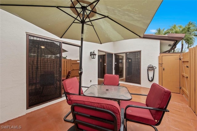 view of patio featuring a gate, outdoor dining area, and fence