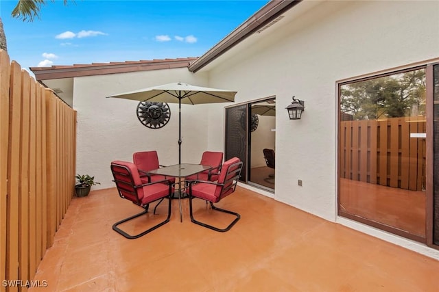 view of patio with outdoor dining space and fence