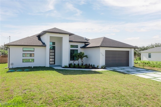 prairie-style house featuring stucco siding, a front lawn, concrete driveway, an attached garage, and a shingled roof