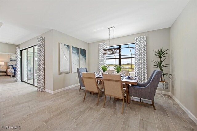 dining room featuring light wood-style flooring and baseboards