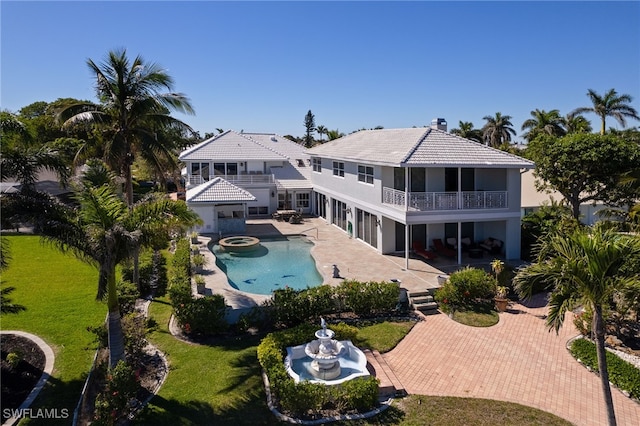 view of pool with a yard, a pool with connected hot tub, and a patio