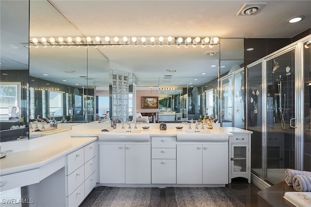 full bath with a sink, a stall shower, and double vanity