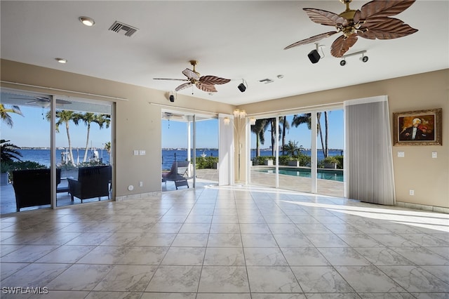 empty room with visible vents, baseboards, and ceiling fan