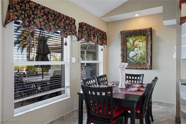 dining space with lofted ceiling and baseboards