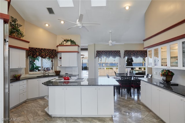 kitchen with visible vents, white cabinets, a sink, and open shelves