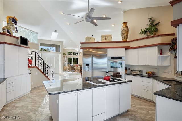 kitchen with white cabinetry, open shelves, appliances with stainless steel finishes, and a center island