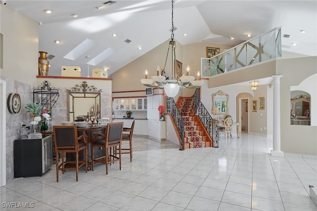 dining area featuring an inviting chandelier, stairway, visible vents, and arched walkways