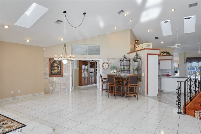 dining space with visible vents, ceiling fan with notable chandelier, and a skylight