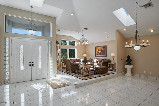 tiled foyer entrance with high vaulted ceiling, a skylight, visible vents, and a chandelier