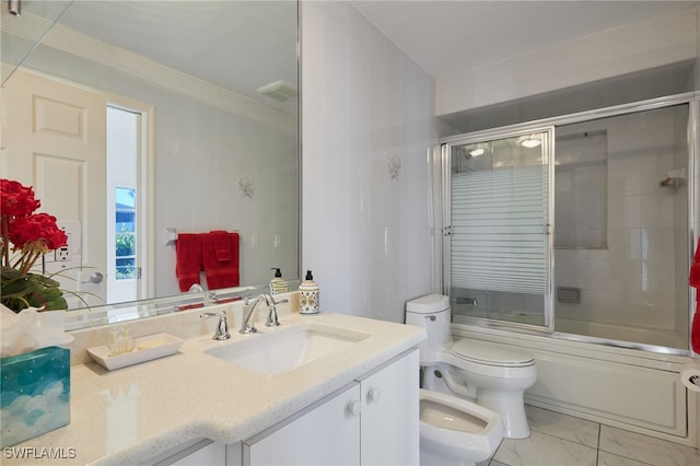 bathroom featuring vanity, toilet, a bidet, and bath / shower combo with glass door