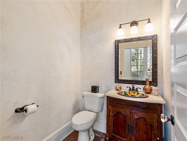 half bath featuring baseboards, toilet, and vanity