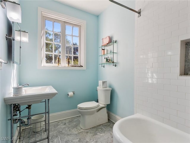 bathroom with toilet, baseboards, and marble finish floor