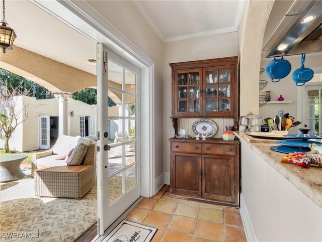 entryway featuring ornate columns, french doors, a wealth of natural light, and ornamental molding