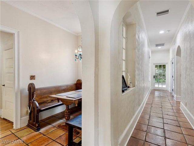 hallway featuring crown molding, arched walkways, and visible vents