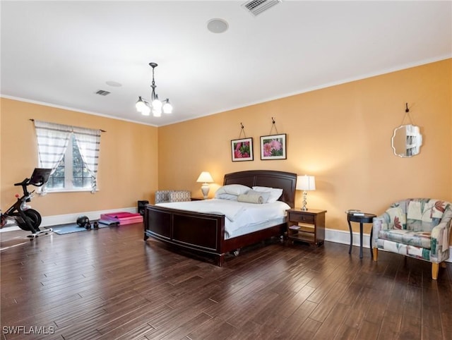 bedroom featuring a chandelier, visible vents, baseboards, and wood finished floors