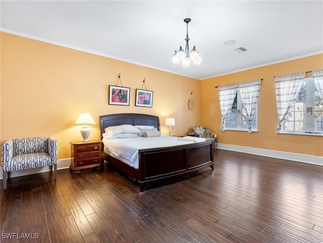 bedroom with baseboards, wood finished floors, visible vents, and a chandelier