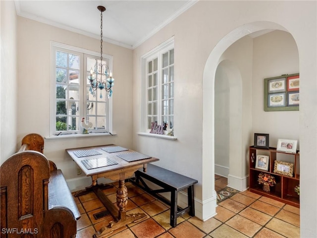 dining area with light tile patterned floors, arched walkways, a chandelier, and ornamental molding