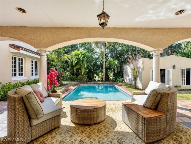 outdoor pool with an outdoor hangout area and a patio area