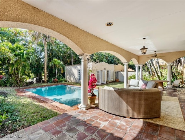 view of patio / terrace with fence, an outdoor pool, an outdoor structure, a storage structure, and an outdoor hangout area