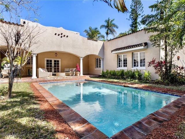 pool featuring outdoor lounge area, a patio, and french doors
