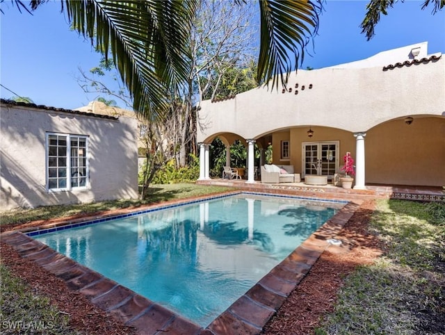 outdoor pool featuring french doors, outdoor lounge area, and a patio