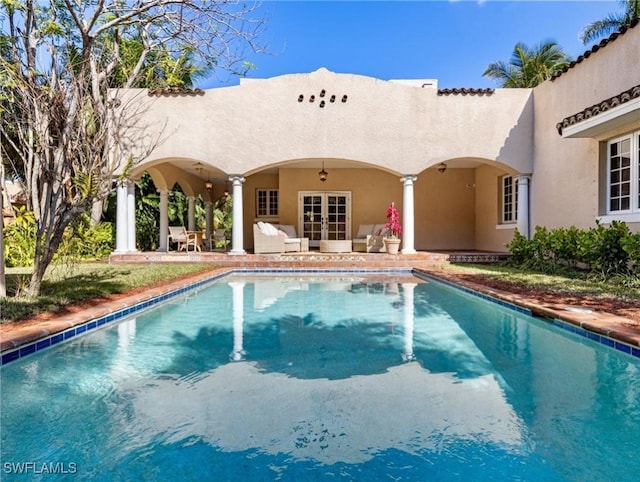 outdoor pool featuring a patio area and french doors