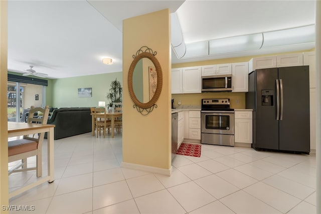 kitchen featuring open floor plan, appliances with stainless steel finishes, white cabinets, light countertops, and light tile patterned floors