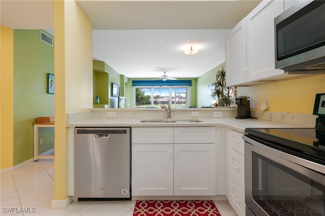 kitchen featuring visible vents, light tile patterned floors, appliances with stainless steel finishes, white cabinetry, and a sink