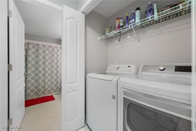 laundry room featuring washer and clothes dryer, laundry area, and light tile patterned flooring