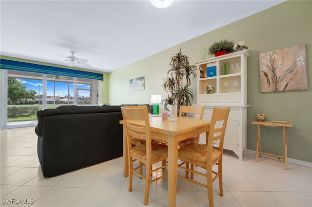 dining space featuring light tile patterned floors, baseboards, and a ceiling fan