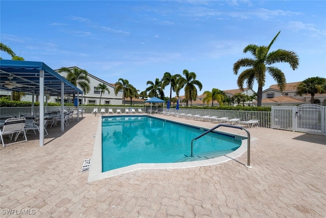 community pool featuring fence and a patio