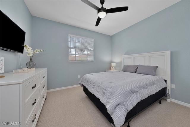 bedroom featuring light carpet, baseboards, and ceiling fan