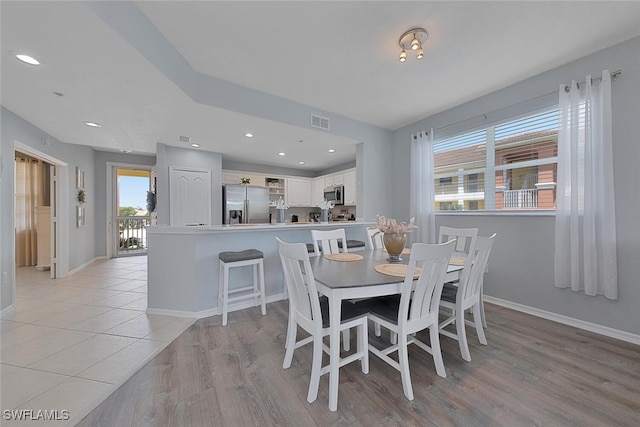 dining room with light wood-style floors, baseboards, and recessed lighting