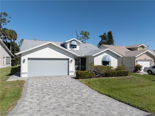 ranch-style home with a front yard, roof with shingles, stucco siding, a garage, and decorative driveway