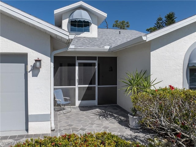 property entrance featuring a patio area, roof with shingles, and stucco siding