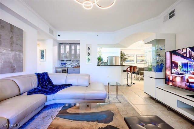 living area featuring light tile patterned floors, visible vents, and ornamental molding