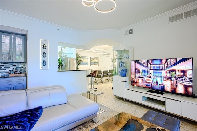 living area with light tile patterned floors, visible vents, and ornamental molding