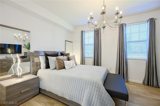 bedroom featuring a chandelier and light wood-type flooring