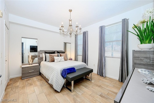 bedroom with light wood-style flooring, baseboards, and a chandelier